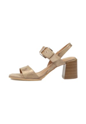 Sandalia beige de punta abierta con amplia tira frontal, correa ajustable en el tobillo con hebilla plateada y tacón grueso de bloque de madera.