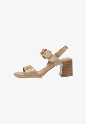 Sandalia beige de punta abierta con amplia tira frontal, correa ajustable en el tobillo con hebilla plateada y tacón grueso de bloque de madera.