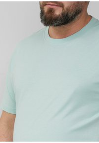 Jasnoniebieska bawełniana koszulka z okrągłym dekoltem i krótkimi rękawami. Posiada małe, wyhaftowane logo na piersi. Miękka faktura.