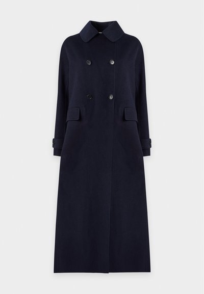 Long manteau bleu marine foncé à double boutonnage avec large col, poches à rabat à l'avant et poignets boutonnés, présenté sur un fond clair uni.