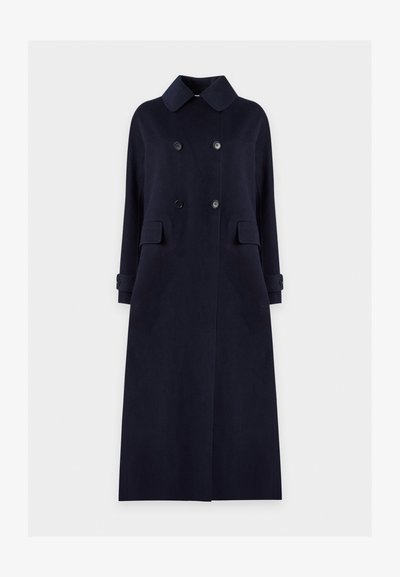 Long manteau bleu marine foncé à double boutonnage avec large col, poches à rabat à l'avant et poignets boutonnés, présenté sur un fond clair uni.