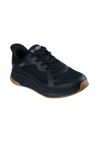 Chaussure de sport noire avec un dessus en maille respirante, semelle en caoutchouc et accents texturés. Dispose de lacets et d'une coque de protection renforcée pour le soutien.