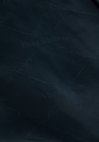 Nahaufnahme eines dunklen Stoffes mit dezenten Mustern und schwach eingewebtem Text, der die Textur und Details zeigt.