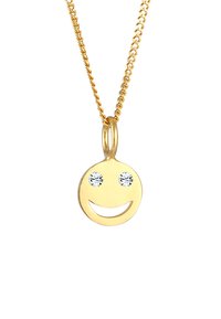 Guld emoji vedhæng halskæde med et smilende ansigt design, accentueret med to klare rhinestones som øjne og en glat, poleret overflade.