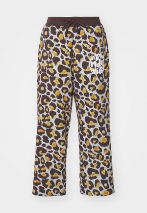 Pantaloni da tuta con stampa leopardata in marrone e giallo, con una vita regolabile tramite lacci e testo bianco "alpha industries" sulla gamba sinistra.
