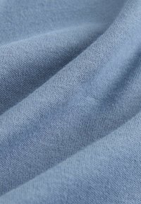 Stofa moale de culoare albastru, cu o textură netedă, prezentând un model cu tricot fin și variații subtile de culoare.