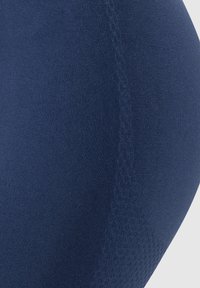 Námořnické modré elastické legíny s hladkým povrchem a jemnými švy, které mají vzorovanou oblast dolní části nohou pro vylepšený design.