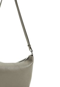 Borsa a spalla in pelle grigia con superficie testurizzata, forma curvata e tracolla regolabile. Presenta una chiusura con zip e hardware minimale.