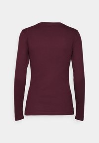Chemise à manches longues en maille côtelée de couleur bordeaux foncé, vue de dos, avec une silhouette ajustée et un col rond.
