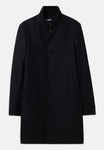 Manteau en laine noir avec un col haut, présentant six boutons à l'avant, deux poches latérales et une coupe droite. Texture lisse.