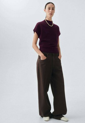 Burgundy knit top with short sleeves and mock neck, paired with loose brown trousers, and white footwear. Simple pearl necklace accent.