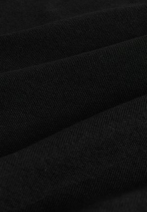 Detailní záběr na složenou černou tkaninu s jemnou diagonální žebrovou strukturou a měkkým, hladkým povrchem.