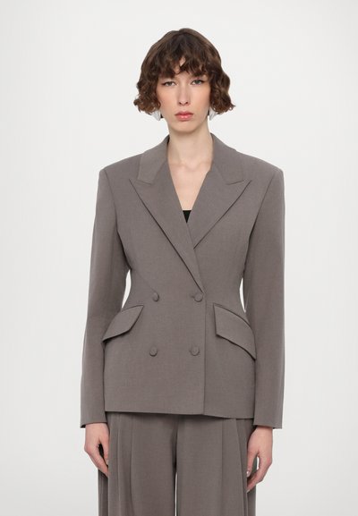 Grau doppelt geknöpfter Blazer mit scharfen Revers, seitlichen Taschen und passgenauer Schnittführung. Glatter Stoff mit weicher Textur, kombiniert mit passender Hose.