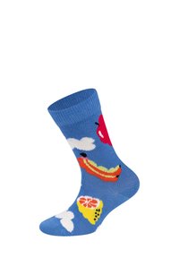 Barevné ponožky se vzory ovoce, mraků a párku v rohlíku, na modrém pozadí, prezentované pod úhlem.