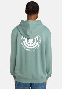 Mint green hoodie with a large white circular graphic on the back. Features a drawstring hood and ribbed cuffs and hem.