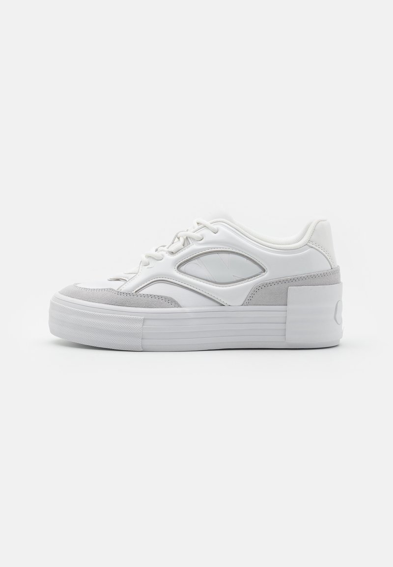 Weißer Sneaker mit grauen Wildleder-Details, ausgestattet mit einer strukturierten Zwischensohle, runder Kappe und Schnürung. Auffälliges seitliches Ausschnitt-Detail.