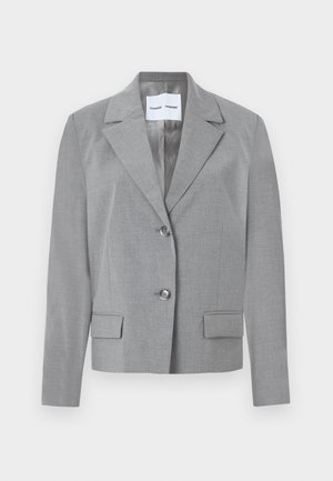 Blazer gris sur mesure avec un col en notch, fermeture à deux boutons et deux poches avant au toucher lisse. Doublure intérieure.
