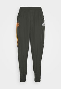 Mörkgrön träningsbyxor gjorda av lättviktsmaterial, med elastisk midja, två sidofickor och orangea och vita ränder med logotyper.