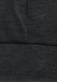 Berretto lavorato a maglia nero con texture a coste e risvolto. Il materiale sembra morbido ed elastico, progettato per calore e comfort.