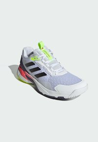 Jasnoszare buty sportowe z przewiewnej siateczki, czarnymi paskami, neonowozielonymi akcentami i wielokolorową gumową podeszwą.