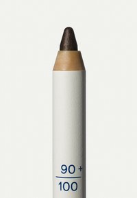 Brauner Lidschattenstift mit strukturierter, cremefarbener Hülle. Die Spitze ist spitz und dunkelbraun, mit einem Etikett, das "90+ / 100" in Blau zeigt.