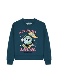 Turquoise sweatshirt met een afbeelding van een cartoon aarde die een vlag vasthoudt, met de tekst "SUPPORT LOCAL" en "SINDS 2010" in roze en zwarte letters.