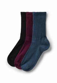 Trzy pary prążkowanych skarpetek typu crew w kolorze czarnym, burgundowym i granatowym, starannie ułożone na białym tle.