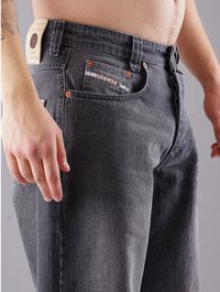 Graue Denim-Jeans mit geradem Schnitt, kupferfarbenen Beschlägen, Seitentaschen und Markenetikett am hinteren Bund. Sichtbares strukturiertes Gewebedetail.