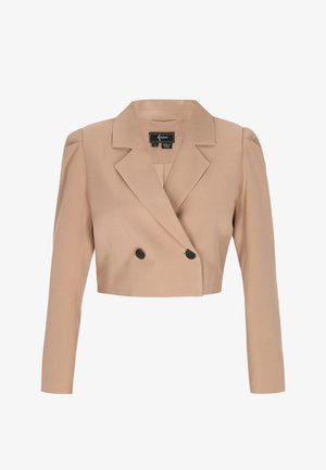 Beige lyhyt bleiseri, jossa pitkät hihat, leveät kaulukset, kaksi mustaa nappia ja hieman pussimaiset olkapäät.