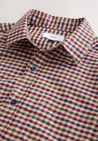 Col et haut de devant d'une chemise à carreaux multicolore avec boutons bleus et une étiquette de marque "NEXT".