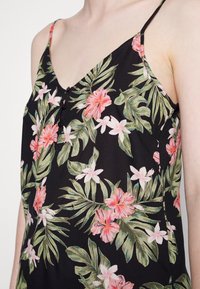 Czarny bezrękawnik z kwiecistym wzorem, zawierający różowe kwiaty i zielone liście, z dekoltem w kształcie litery V oraz małymi czarnymi guzikami z przodu.