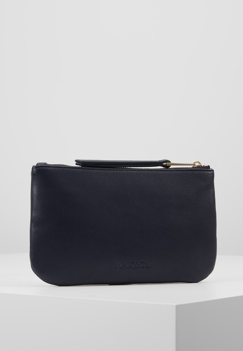 Pochette en cuir marine avec une texture lisse, fermeture éclair et une petite poignée. Présente un logo embossé à l'avant.