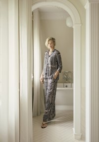Luftiges Pyjama-Set in Marineblau mit wellenförmigem beigefarbenen Muster. Das Oberteil hat ein knöpfbares Design und lange Ärmel; die Hose ist mit einem elastischen Taillenbund ausgestattet.