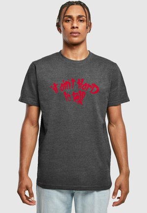 Grå bomulds t-shirt med rød tekst, der står "det er ikke svært at se," i et buet design. Korte ærmer og rund halsudskæring.