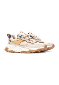 Zapatillas de color neutro con una parte superior texturizada, que cuentan con acentos en beige y azul, y un diseño de suela moteada en blanco y marrón.
