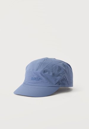 Casquette bleue Soar à visière incurvée et munie d’orifices d’aération, sur un fond clair uni.