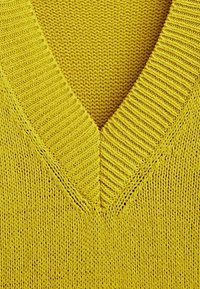 Pull jaune tricoté présentant un col en V avec une texture côtelée au niveau du col et un motif de tricotage lisse sur l'ensemble.