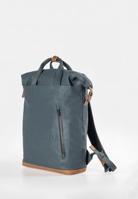 Blauer Rucksack mit rollbarer Oberseite, vorderer Vertikalreißverschlusstasche, grünen Griffen, braunen Akzenten und gepolsterten Schultergurten, der auf weißem Hintergrund aufrecht steht.