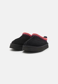 Svarta mocka slip-in skor med en texturerad rödrosa broderad kant längs toppen och en flexibel gummisula.