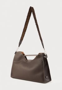 Brown textured leather handbag with a structured shape, abstract cut-out top, and a braided strap. Silver hardware accents.