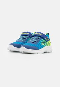 Modré a zelené atletické topánky s textúrovaným zvrškom, elastickými šnúrkami a bielou gumovou podrážkou. Obsahujú pásik so značkovaním "SKECHERS".
