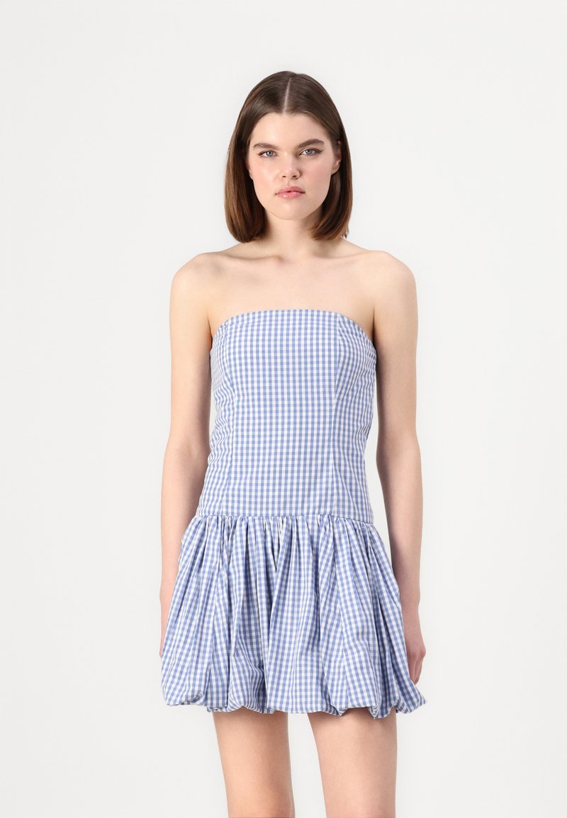 Robe sans bretelles en vichy bleu et blanc, avec une jupe bouffante plissée et un corps lisse avec un haut élastique.