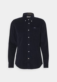 Chemise en velours côtelé bleu marine à manches longues avec col boutonné, poche poitrine avant et boutons blancs, marque Barbour sur la poche et à l'intérieur du col.