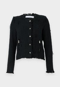 Musta teksturoitu takki, jossa on repaleinen helma, hopeiset nappivaihteet ja sivuvetoketjulliset taskut. Sisältää lyhyemmän leikkauksen ja pitkät hihat.