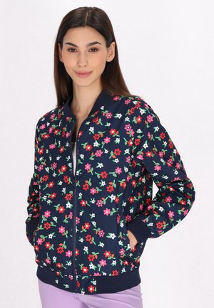 Bloemige bomberjack in marineblauw met meerkleurige bloemen. Voorzien van een rits aan de voorkant, geribde mouwen en zoom; lichtgewicht stof.
