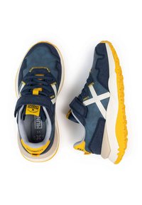 Sneakers blu navy con finitura testurizzata, dettagli gialli, strisce bianche e suole in gomma. Presentano lacci e una fascia in velcro per la chiusura.