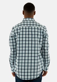 Achteraanzicht van een heren overhemden met een blauw, zwart en crème geruit patroon, lange mouwen en een klassieke kraag.