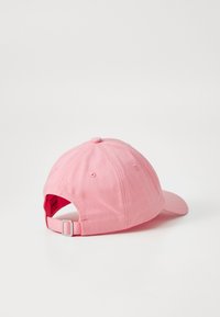 Rosa bomull baseball cap med buet brem, justerbar bakrem med metallhardware, og en teksturert stoffoverflate.