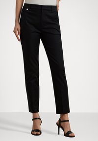 Black tailored trousers with a straight leg fit, featuring a smooth texture and a discreet brand logo on the waistband.