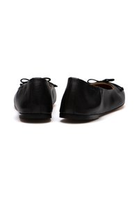 Ballerine in pelle nera con punta arrotondata, suola piatta e dettagli decorativi a fiocco sulla parte anteriore. Texture liscia, design minimalista.